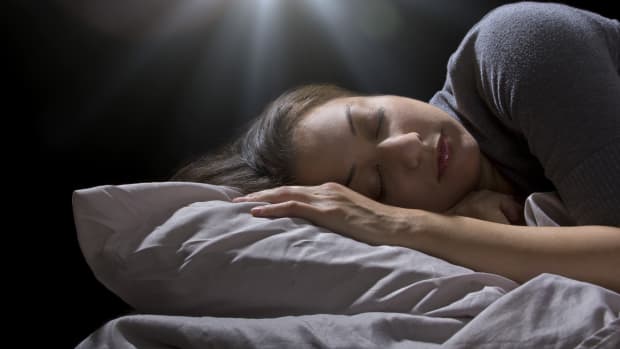 发光的球体悬停在一个女人睡觉。